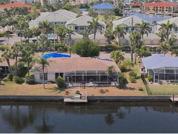 Waterfront home featuring a screened lanai, dock, and easy access to water activities at 1450 Aqui Esta Dr, Punta Gorda, FL 33950