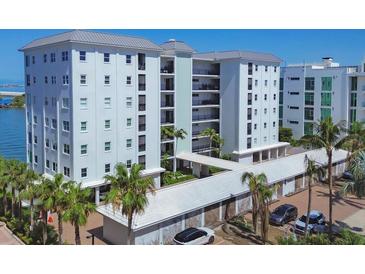 Stunning condo building featuring multiple levels, private balconies and lush landscaping with palm trees at 226 Golden Gate Pt # 63, Sarasota, FL 34236
