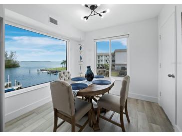 Bright dining room features a water view and a wood table with four chairs at 3320 Gulf Of Mexico Dr # 208C, Longboat Key, FL 34228