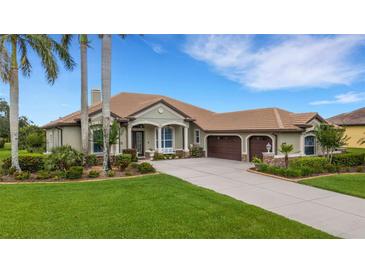 Charming single-story home with a tile roof, lush landscaping, a paver driveway and a two-car garage at 385 165Th Ne Ct, Bradenton, FL 34212