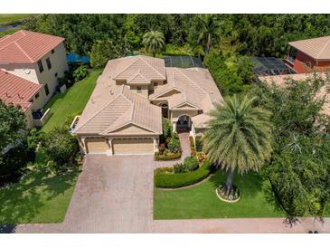 Stunning aerial view of the house showcasing its tile roof, three car garage, and lush landscaping at 4584 Tuscana Dr, Sarasota, FL 34241