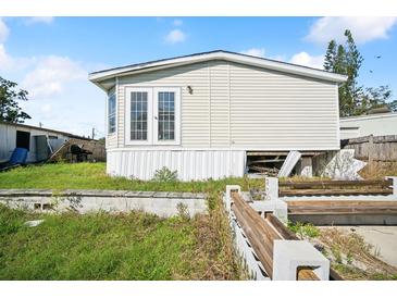 Exterior view showing a quaint mobile home with white siding and manicured lawn at 5829 Coventry Dr, Tampa, FL 33615