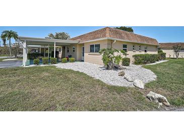 Cozy home with a carport, manicured bushes, rock garden, and well-maintained grassy lawn at 602 Park Cir, Bradenton, FL 34207