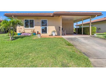 Charming home with a well-manicured lawn, colorful flowers, and a convenient covered carport for easy parking at 6422 Auburn Ave, Bradenton, FL 34207