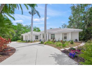 Stunning home featuring a circular driveway, a well manicured lawn and vibrant flowering shrubs at 924 Indian Beach Dr, Sarasota, FL 34234