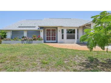 Charming single-story home featuring a well-maintained lawn, colorful flower beds, and a brick-paved walkway to the front door at 104 Hourglass Dr, Venice, FL 34293