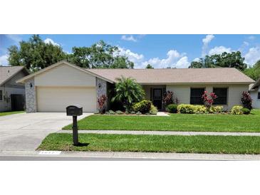 Charming single-story home featuring well-manicured lawn and landscaping under a blue sky at 1612 Shady Leaf Dr, Valrico, FL 33596