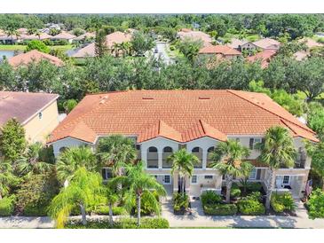 An aerial view of a residential building with a red tile roof and lush green landscaping at 3760 82Nd Avenue E Cir # 102, Sarasota, FL 34243