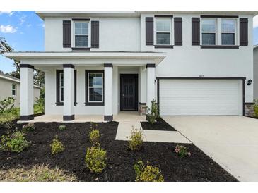 Charming two-story home with a well-manicured lawn and a welcoming front porch, garage, and decorative shutters at 4015 Quiet Rain Ct, Palmetto, FL 34221