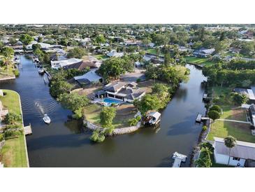 Beautiful aerial view of a canal-front home featuring a private pool and boat dock at 5500 Merrimac Dr, Sarasota, FL 34231