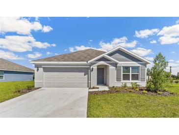 Charming single-story home featuring a two-car garage, manicured lawn, and craftsman-style details at 10845 Gentle Current Way, Parrish, FL 34219