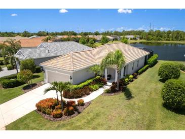 Beautiful single-story home with a tile roof, well manicured lawn and view of the lake at 12116 Stuart Dr, Venice, FL 34293