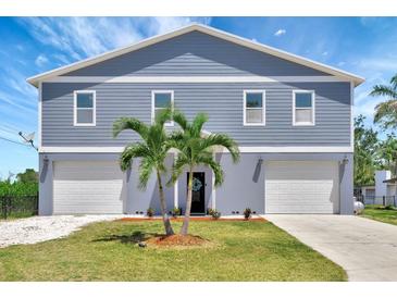 Charming two-story home featuring a double garage, well-manicured lawn, and decorative palm trees at 217 22Nd Street Ne Ct, Bradenton, FL 34208