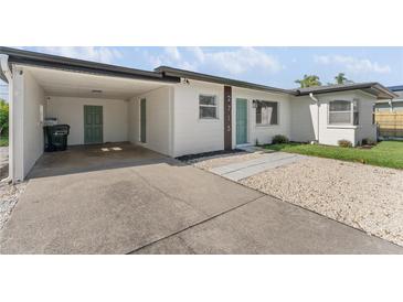 Charming single-story home features a carport, crisp white paint, and a neatly maintained front yard at 2715 Herwald St, Sarasota, FL 34231