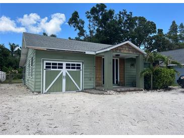 Charming home featuring a unique garage door, covered entry and mature landscaping at 2722 9Th Ave W, Bradenton, FL 34205