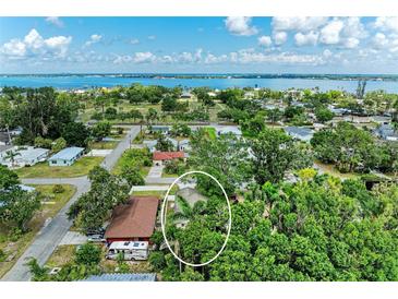 Aerial view of a property showcasing lush landscaping, mature trees, and proximity to the waterfront at 4115 2Nd Nw Ave, Bradenton, FL 34209