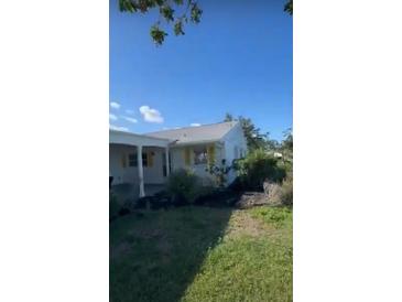 Cozy single-story home with a metal roof, white siding, yellow shutters, and a covered carport at 4408 Mount Vernon Dr, Bradenton, FL 34210