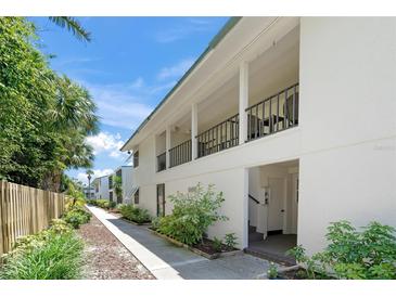 Inviting condo exterior with lush landscaping and a walkway leading to the entrance at 5681 Midnight Pass Rd # 104, Sarasota, FL 34242