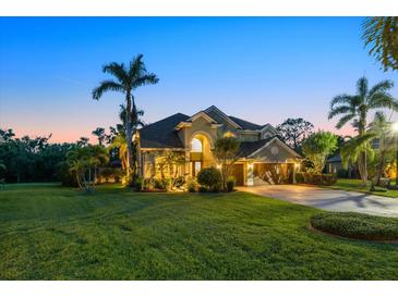 Beautiful two-story home with a lush lawn and meticulous landscaping at dusk at 6907 47Th E Ct, Ellenton, FL 34222