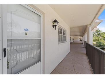 Condo entryway featuring a secure door, hallway, and decorative lighting at 860 Virginia St # 304, Dunedin, FL 34698
