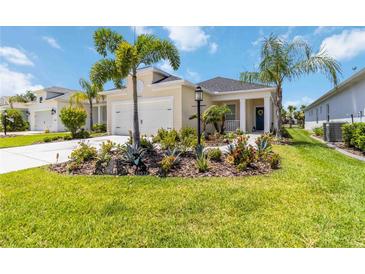 Charming home with a well-manicured lawn, lush landscaping, and inviting front entrance at 10926 Sand Pine Ln, Parrish, FL 34219