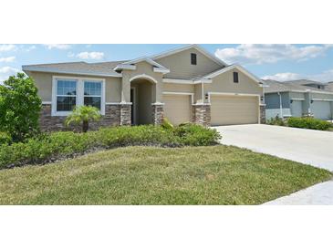 Charming single-story home with a two-car garage and stone accents, with beautiful landscaping at 17536 Cantarina Cv, Bradenton, FL 34211