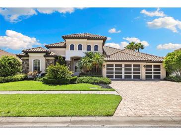 Beautifully landscaped front yard of a luxury home, showcasing a manicured lawn and a three-car garage at 2152 Majestic Oaks Blvd, Clearwater, FL 33759