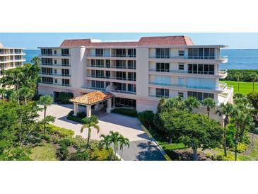Beautiful exterior shot of this condo building, including entrance and meticulously maintained landscaping with mature palms at 3070 Grand Bay Blvd # 644, Longboat Key, FL 34228