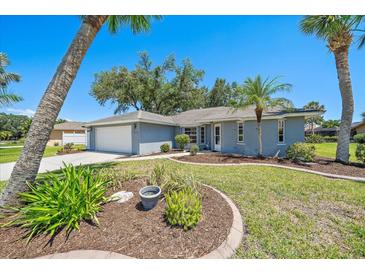 Charming single-story home with a well-manicured lawn, lush landscaping, and an attached two-car garage at 3335 Meadow Run Ter, Venice, FL 34293