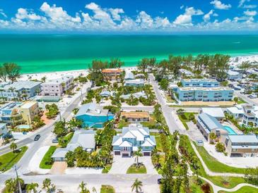 Stunning aerial view of a beautiful beach neighborhood and stylish home with lush landscaping at 3702 5Th Ave, Holmes Beach, FL 34217