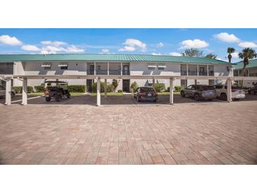 Exterior view of condo's parking with ample covered parking spaces and well-maintained brick driveway at 5623 Midnight Pass Rd # 615, Sarasota, FL 34242