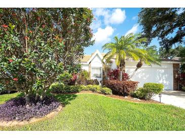 Charming home featuring lush landscaping, healthy green lawn, and a variety of plants and flowers at 5812 Garden Lakes Fern, Bradenton, FL 34203
