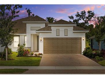 Charming home featuring a two-car garage, brick paver driveway, and manicured landscaping at 5816 Mezzana Run, Palmetto, FL 34221