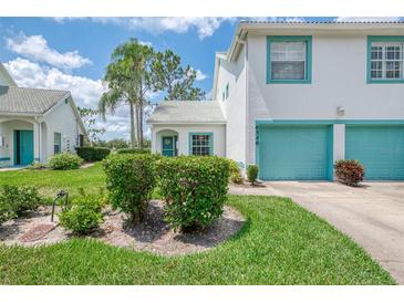 Charming two-story home with a two car garage, lush lawn and teal trim accents at 6546 Fairway Gardens Dr # 6546, Bradenton, FL 34203