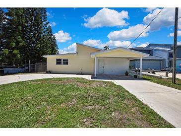 Charming single-story home with a covered carport and well-maintained front lawn on a sunny day at 7308 Maryland Ave, Hudson, FL 34667
