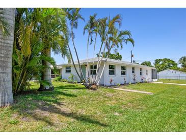 Charming single-story home featuring a well-maintained lawn, beautiful palm trees, and a welcoming facade at 1200 25Th W Ave, Palmetto, FL 34221