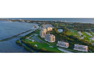 Stunning aerial view of a luxury condo community with a marina, golf course, and ocean views at 3060 Grand Bay Blvd # 182, Longboat Key, FL 34228