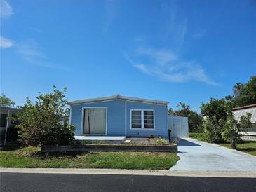 Charming single-story home featuring blue siding, a sliding glass door entry, and a well-kept lawn at 3212 Oakwood S Blvd, Sarasota, FL 34237