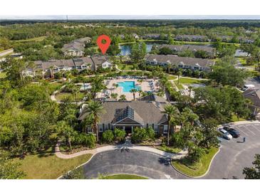Aerial view of community featuring a pool, clubhouse, palm trees and tranquil lake at 8926 Manor Loop # 201, Lakewood Ranch, FL 34202