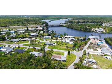Aerial view of neighborhood with home on grassy corner lot near waterway at 156 Myakka Rd, Venice, FL 34293