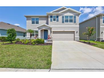 Charming two-story home with a well-manicured lawn and a two car garage at 17330 Harvest Moon Way, Bradenton, FL 34211