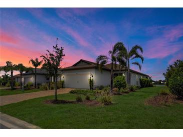 Charming single-story home with a two-car garage, lush landscaping, and a brick-paved driveway at sunset at 17725 Northwood Pl., Bradenton, FL 34202