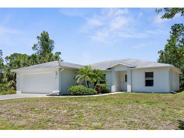 Charming single-story home featuring a well-maintained lawn, a two car garage, and decorative plants at 2575 Johannesberg Rd, North Port, FL 34288