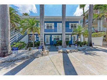 Charming blue two-story home with white trim, tropical landscaping, and reserved parking at 301 Highland Ave # 3, Bradenton Beach, FL 34217