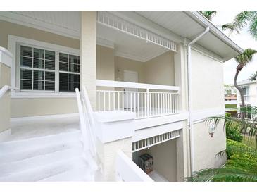 Exterior view of a two-story home with white railings and stairs, showcasing a charming architectural style at 3803 54Th W Dr # 201, Bradenton, FL 34210