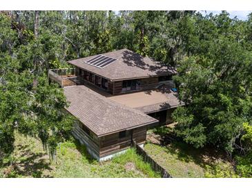 Stunning two-story home with solar panels and a deck nestled amongst mature trees at 9625 Erie Rd, Parrish, FL 34219