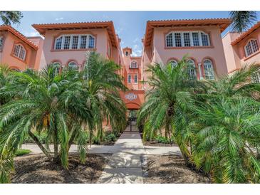Charming condo building with lush tropical landscaping, secure gated entry, and classic architectural details at 1221 N Palm Ave # 303, Sarasota, FL 34236