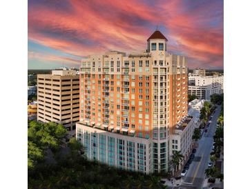 Beautiful high-rise building featuring tan brick, balconies, and a charming cupola, all under a vibrant sunset sky at 1350 Main St # 1703, Sarasota, FL 34236