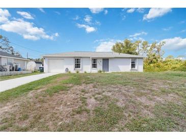 Charming one-story home with a well-manicured lawn, an attached garage, and inviting curb appeal at 2341 Sheila Ln, North Port, FL 34286