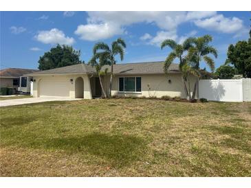 Charming single-story home featuring a well-maintained lawn, palm trees, and a two-car garage at 48 Dade Ave, Sarasota, FL 34232